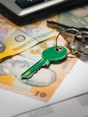 Close-up of Romanian banknotes with a set of keys, representing real estate investment and financial planning.